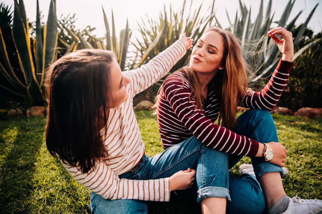 teenage-girls-having-fun-in-the-park_t20_AerXvV two friends smiling at each other