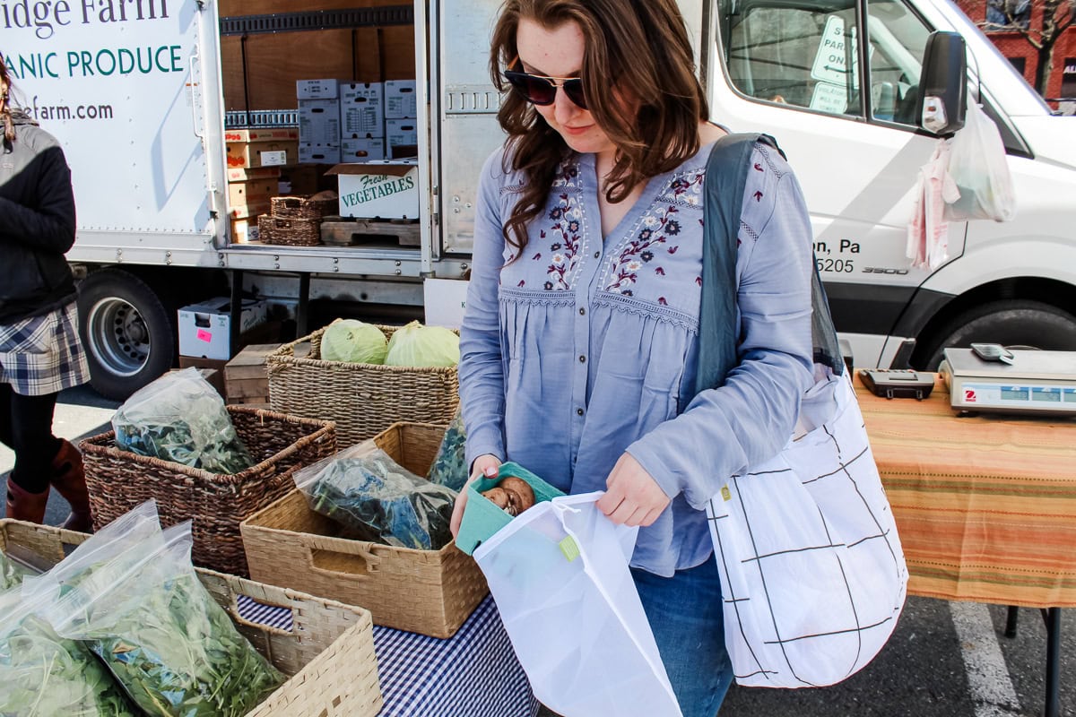 Using a mesh produce bag at a farmer's market.