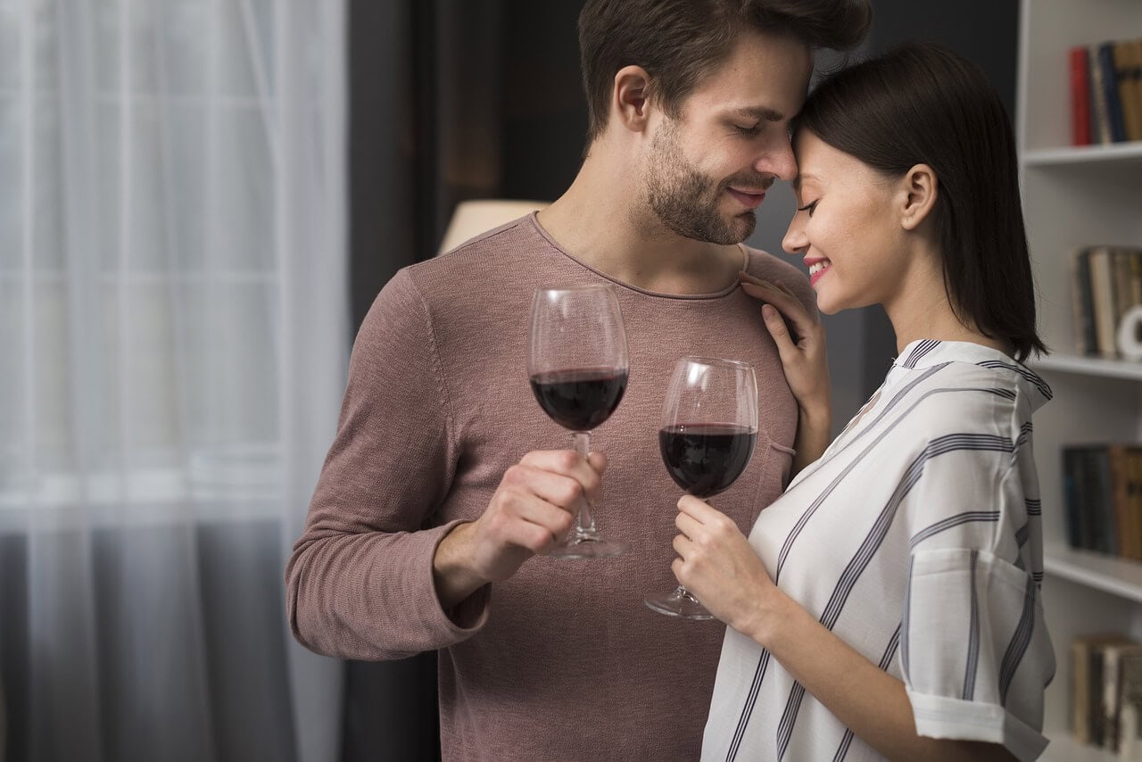 coppia che beve vino sorridendo