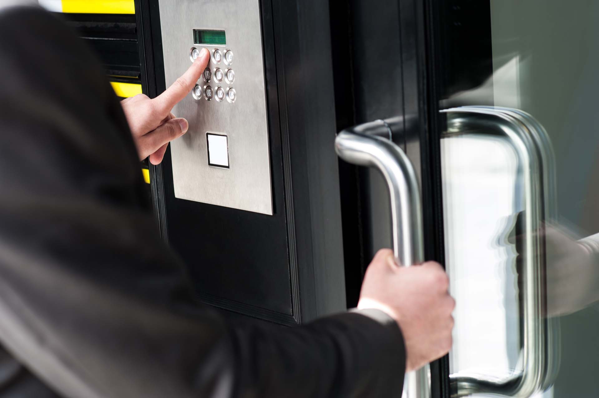 Person öffnet eine Tür mit einem elektronischen Zutrittsystem