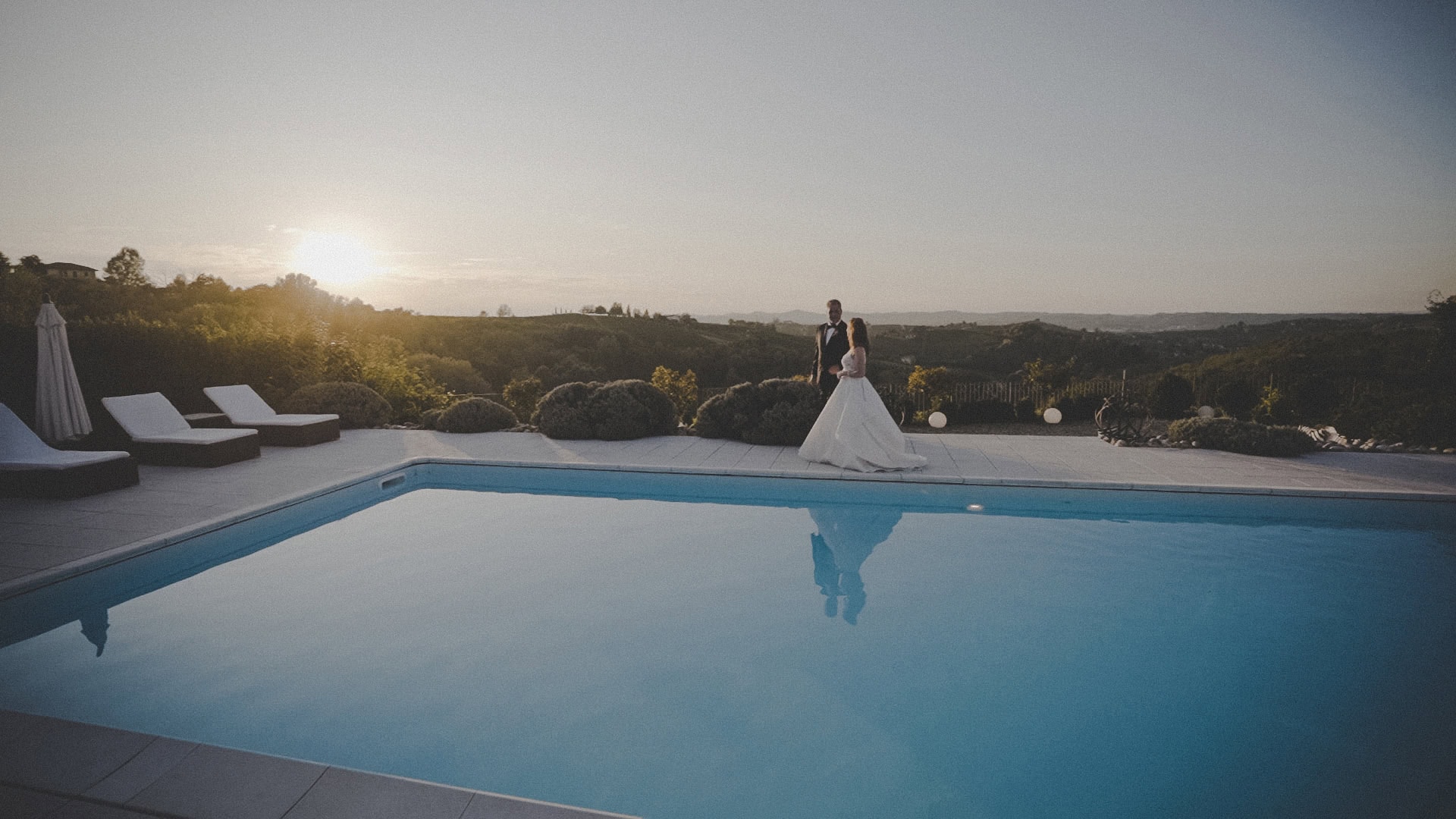 sposi bordo piscina sposi al tramonto sul bordo di una piscina