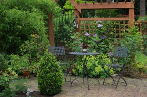 Gemütliche kleine Hinterhofterrasse mit Tisch und Stuhl im Garten.