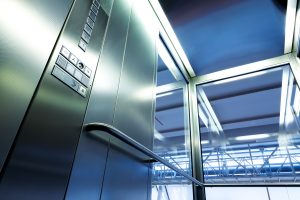 Hydraulikaufzug-Materialien-tipp-zum-bau Innenraum eines Glasaufzugs mit Metallleiste.