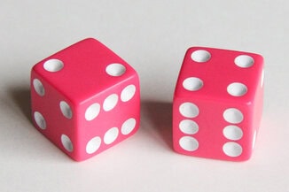 A photo showing two pink dice, showing the numbers 2 and 4.