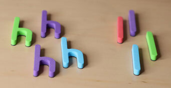 Photo of colorful letter magnets that are sorted by letter (h and l.)