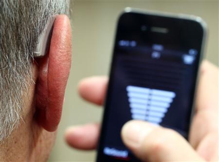 Employee of GN, the world's fourth largest maker of hearing aids, demonstrates the use of ReSound LiNX in Vienna setting phone for travel