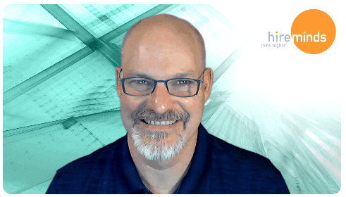 A person wearing glasses and smiling at the camera
Description automatically generated