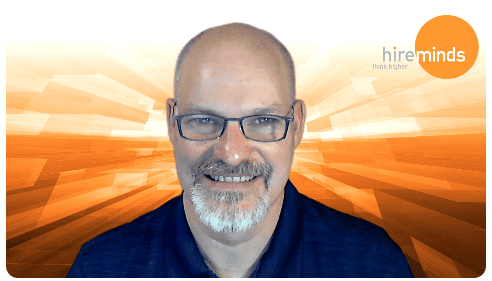 A person wearing glasses and smiling at the camera
Description automatically generated