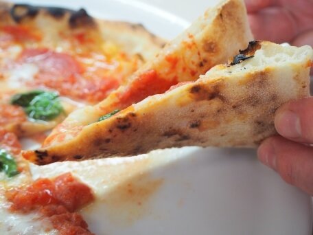 pizza napoletana verace fatta in casa flessibile e maculata.