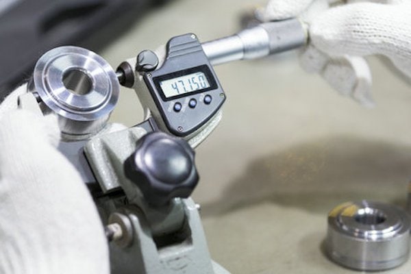 operator inspection automotive part by micrometer