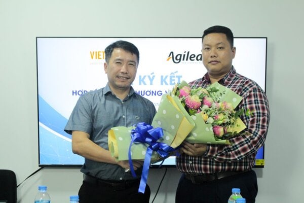 Hai đại diện doanh nghiệp trao tặng hoa sau khi ký kết