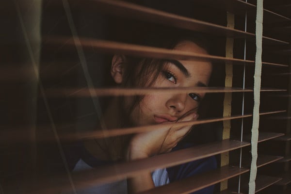 social distancing boredom woman looking out of window bored