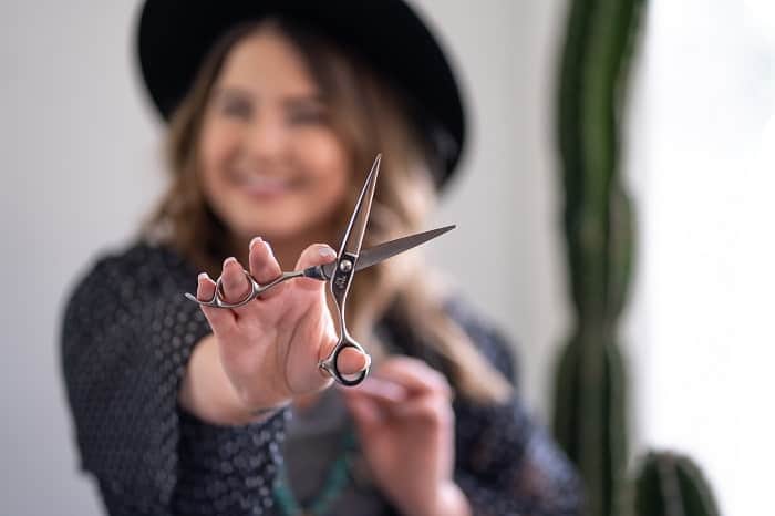cutting someone off for good woman smiling holding scissors