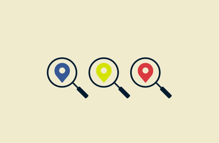Magnifying glasses with primary colored map pins.