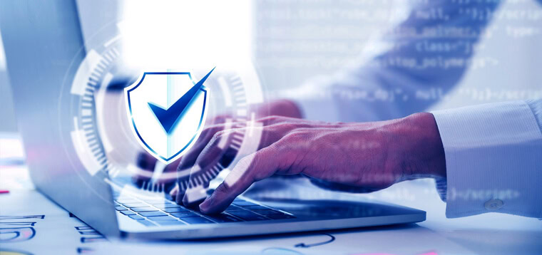 Homem digitando em um laptop na frente de um escritório. Alusão à lgpd