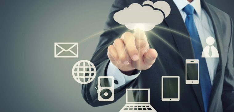 Mão clicando uma nuvem que está enviando informações para diversos dispositivos