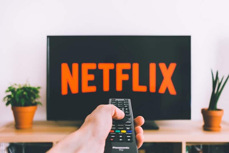 self care ideas positive film hand holding remote with netflix