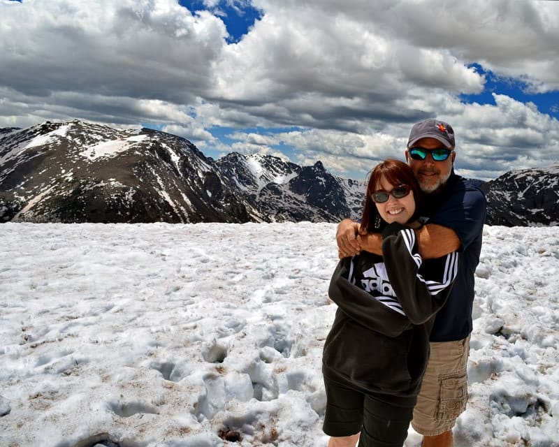 Brooke and her dad on trail ridge road
in colorado with snow on the ground and a beautiful blue sky