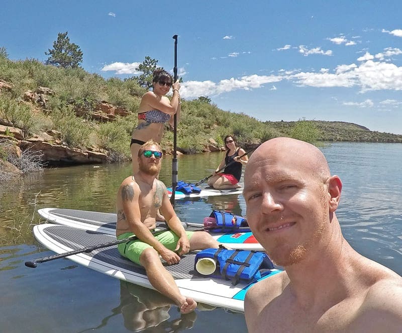 Brooke and Buddy paddleboarding with their friends on Horsetooth Resoivior in Fort Collins Colorado