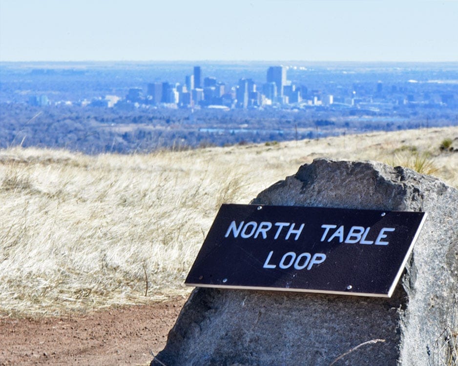 North Table Loop sign with the Denver city line in the background.
