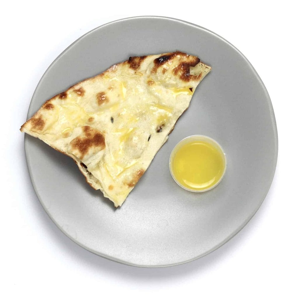 Piece of naan bread brushed in hot, melted ghee