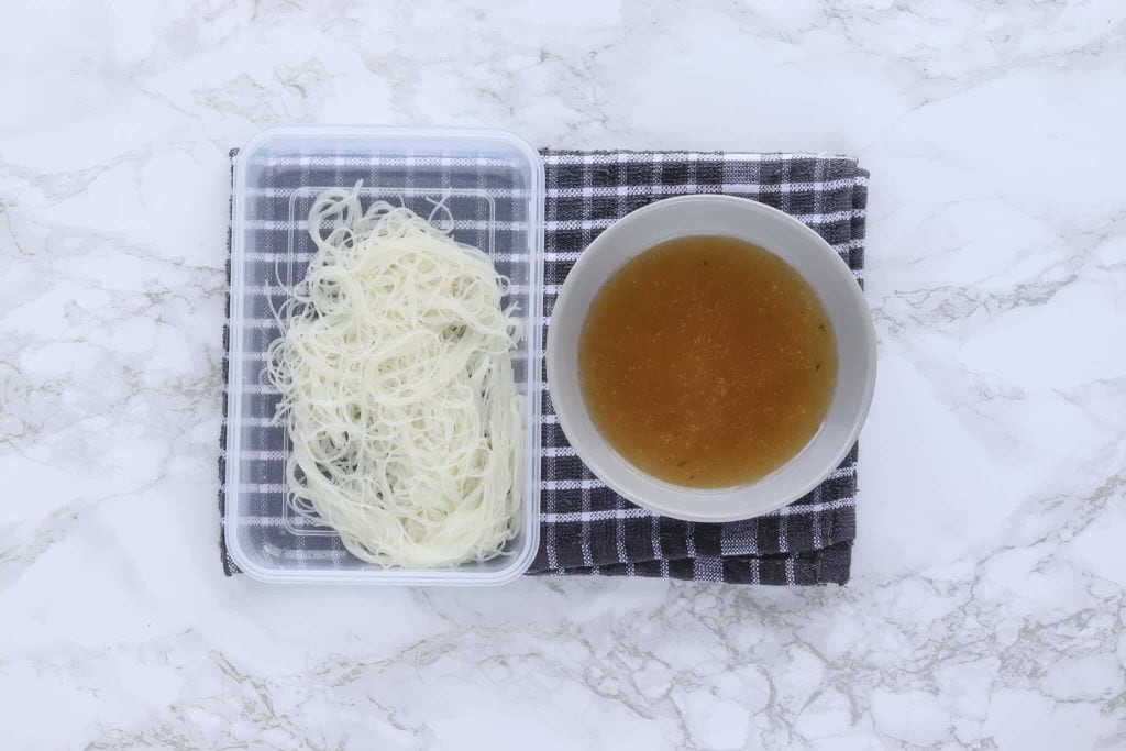 Rice noodles next to broth.