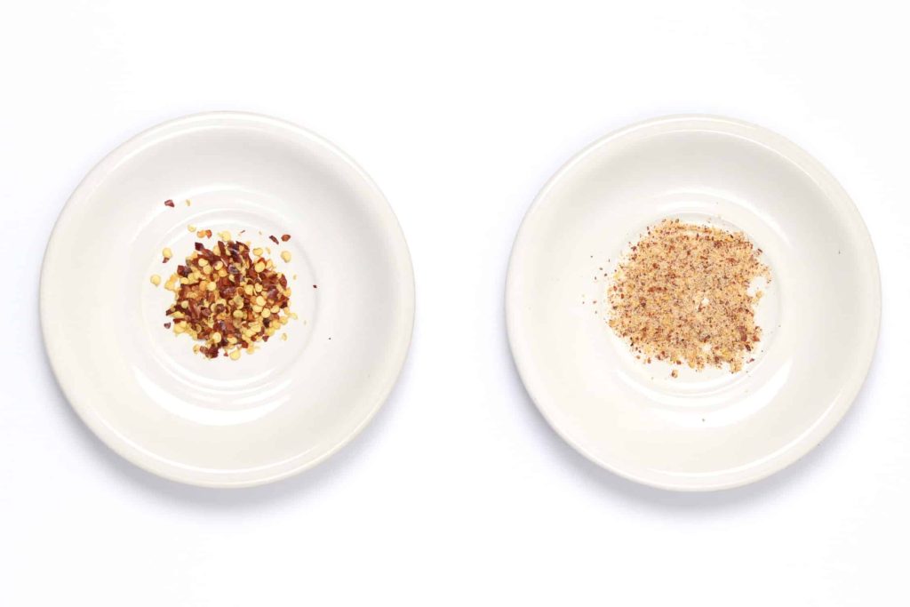 Side by side comparison of chilli flakes VS blended chilli popcorn seasoning with salt and chilli powder.