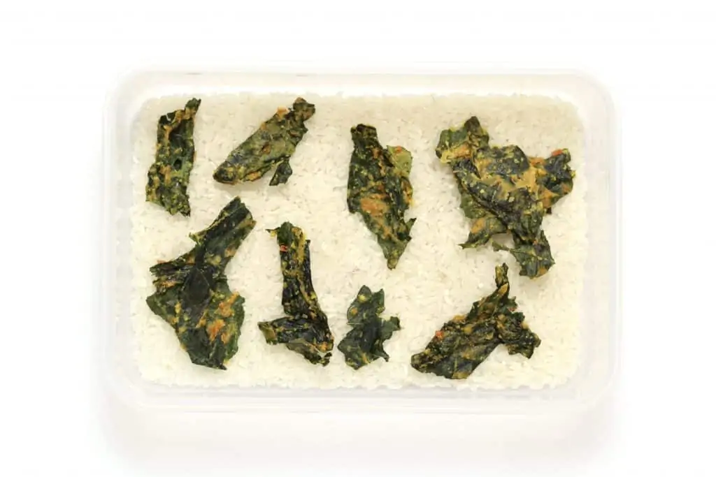 Crispy kale chips stored with rice in an airtight container to prevent moisture