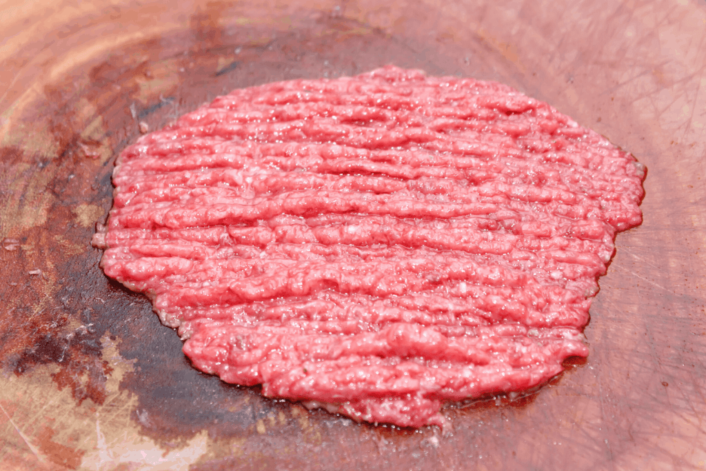 Mushy, unappetizing, warm ground beef on a chopping board