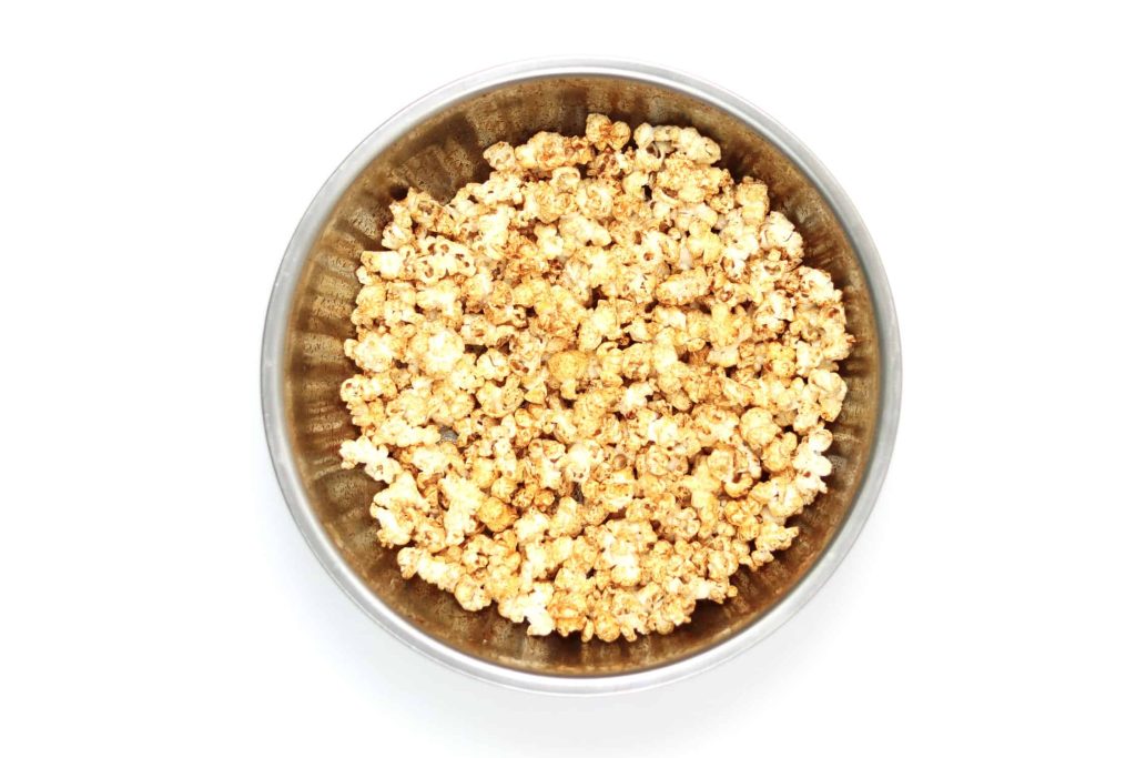 Popcorn coated in sweet paprika seasoning in a large metal bowl