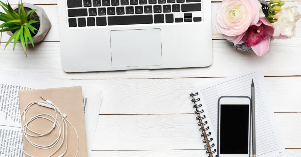 Image of desktop with flowers, laptop and open notebook and text "10 Bad Habits that Sabotage Your Success"