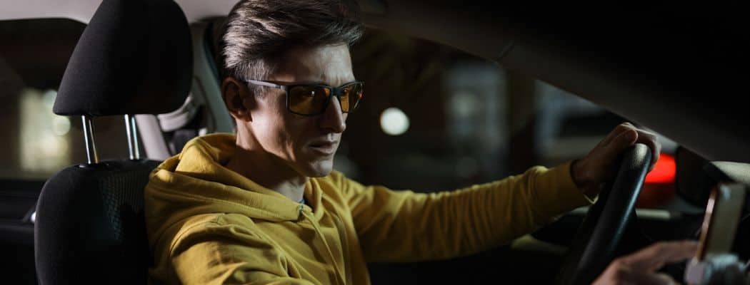 man at night with driving glasses car dashboard