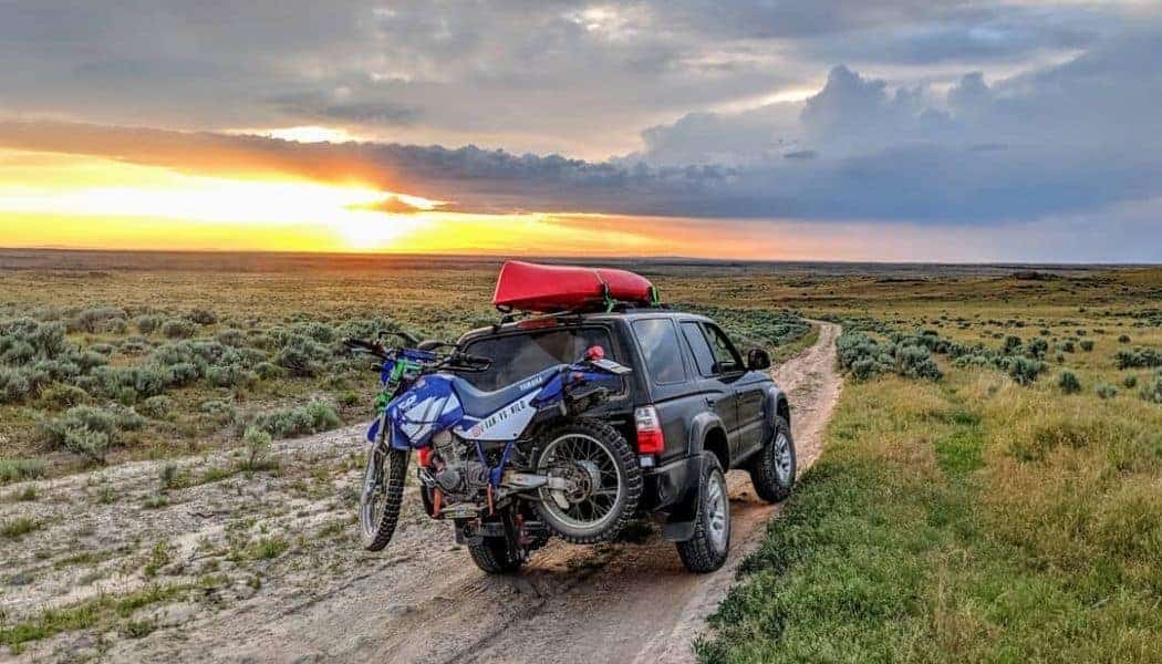 motorcycle in a hitch carrier in a jeep with mountain