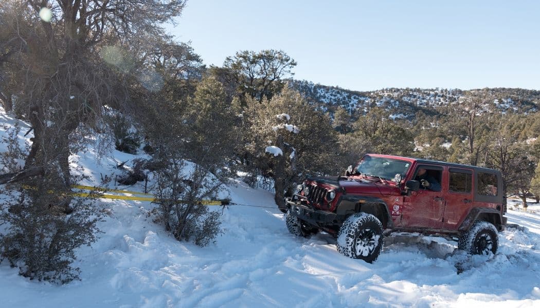 red jeep using winch in a snow