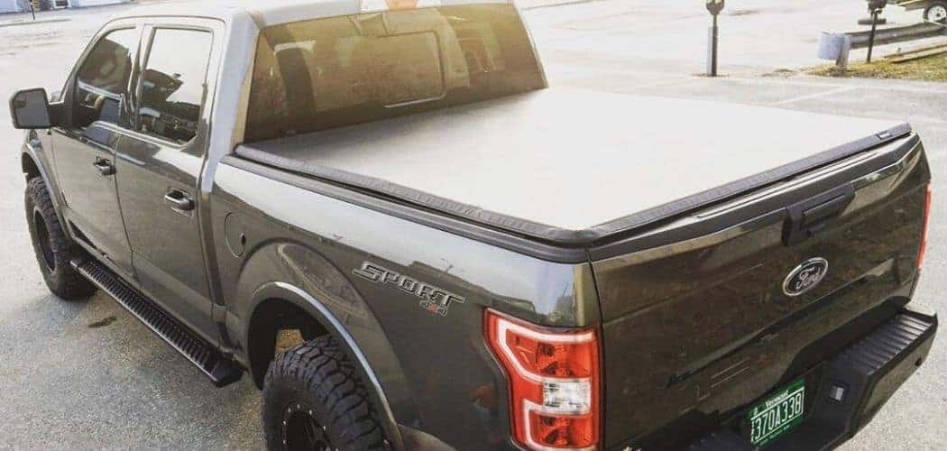 ford f150 with tonneau and bed cover along road