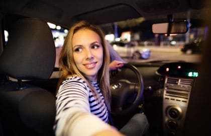 woman reversing a car with rear view mirror