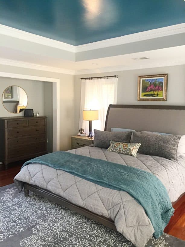 a transitional bedroom with a cloud gray wall and teal ceiling