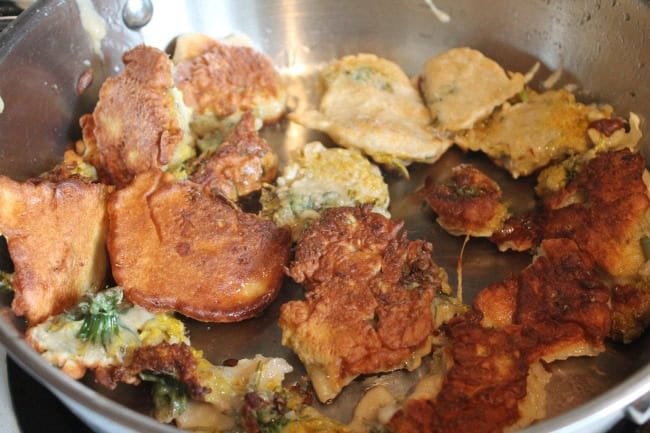 Fried dandelion fritters freshly cooked in a pan, ready to enjoy.