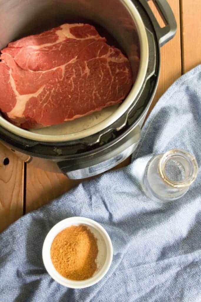 An overhead shot of a beef roast in an instant pot.