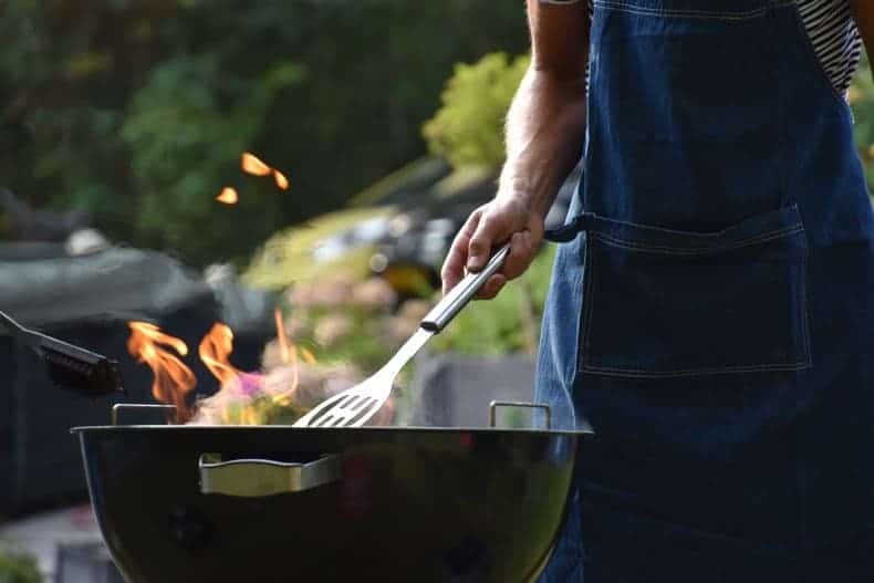 lower half of man cooking meat on a grill to suggest bbq gift ideas for dads