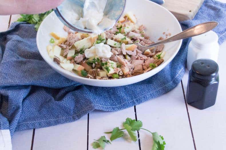 Mayonaise dressing is poured onto the salad mixture.