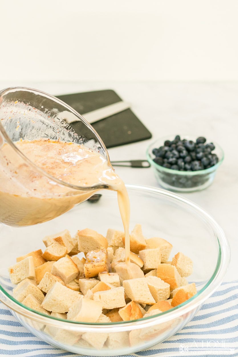 milk mixture pouring into bread cubes