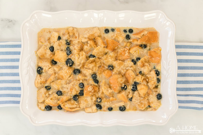 uncooked lemon blueberry bread pudding in a baking dish