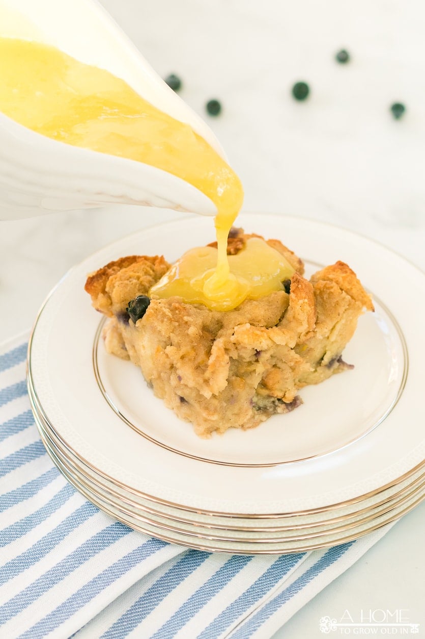 lemon blueberry bread pudding on a plate with lemon curd sauce poured on top