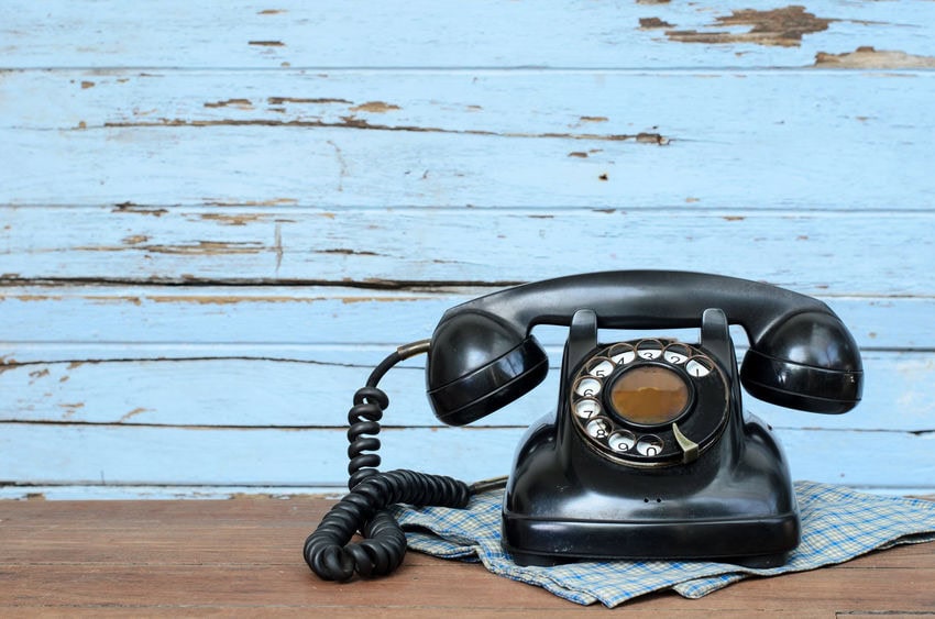 Old telephone on wood background.