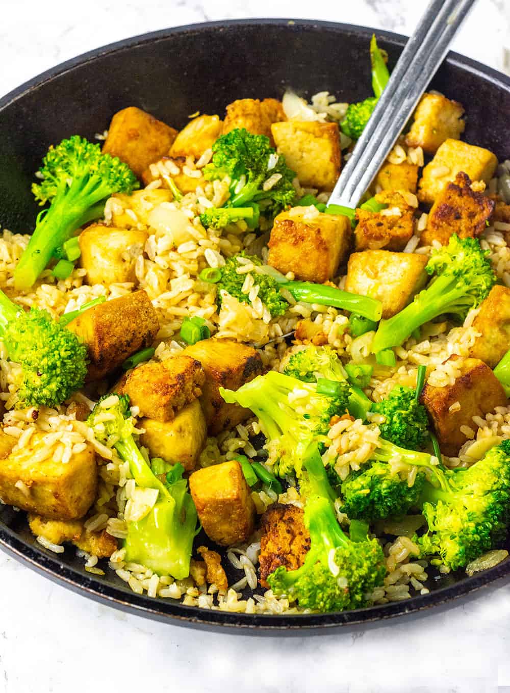 Marinated tofu fried rice with broccoli and seasoned tofu in a skillet