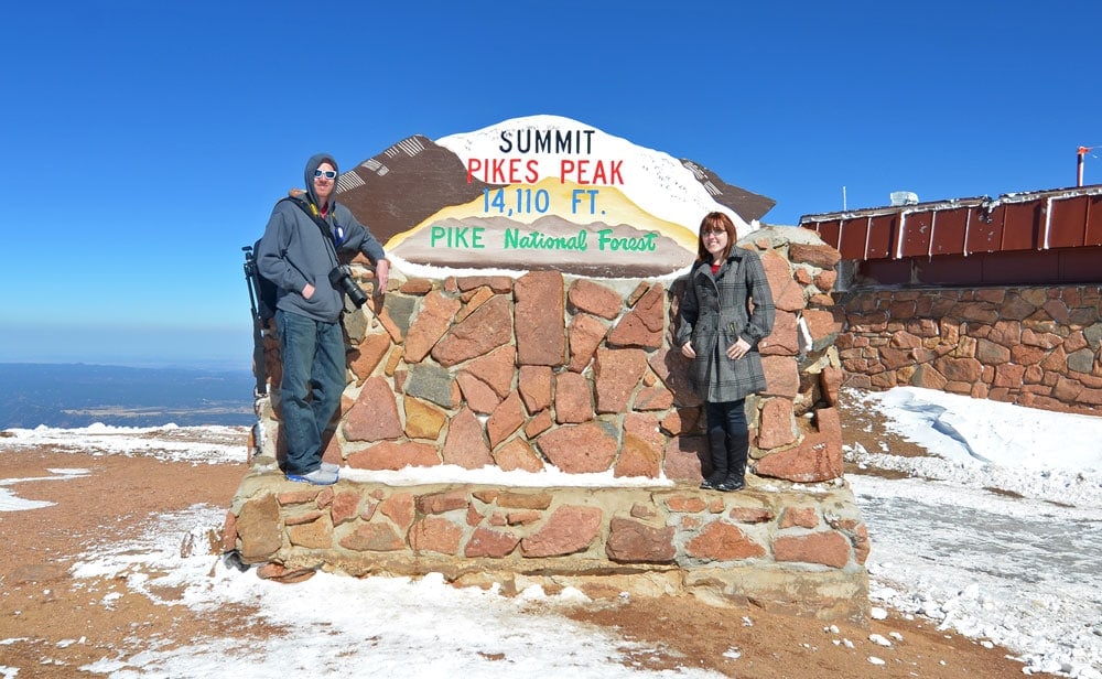 Brooke and Buddy posing in front of the Pikes Peak Summit sign