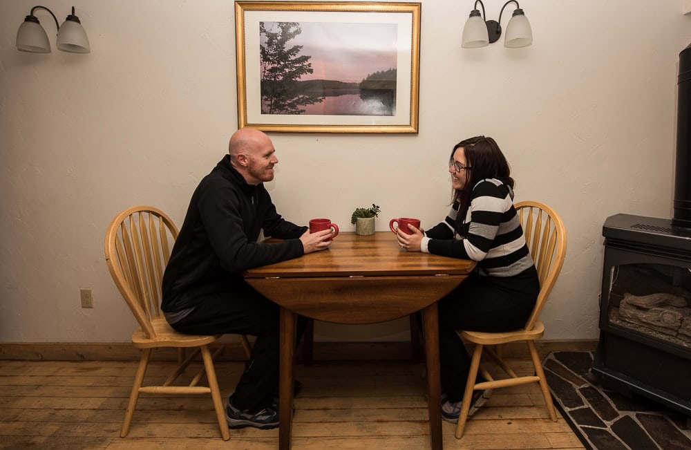 Brooke and Buddy sitting at the table chatting in their Colorado Cabin Adventures in Grand Lake