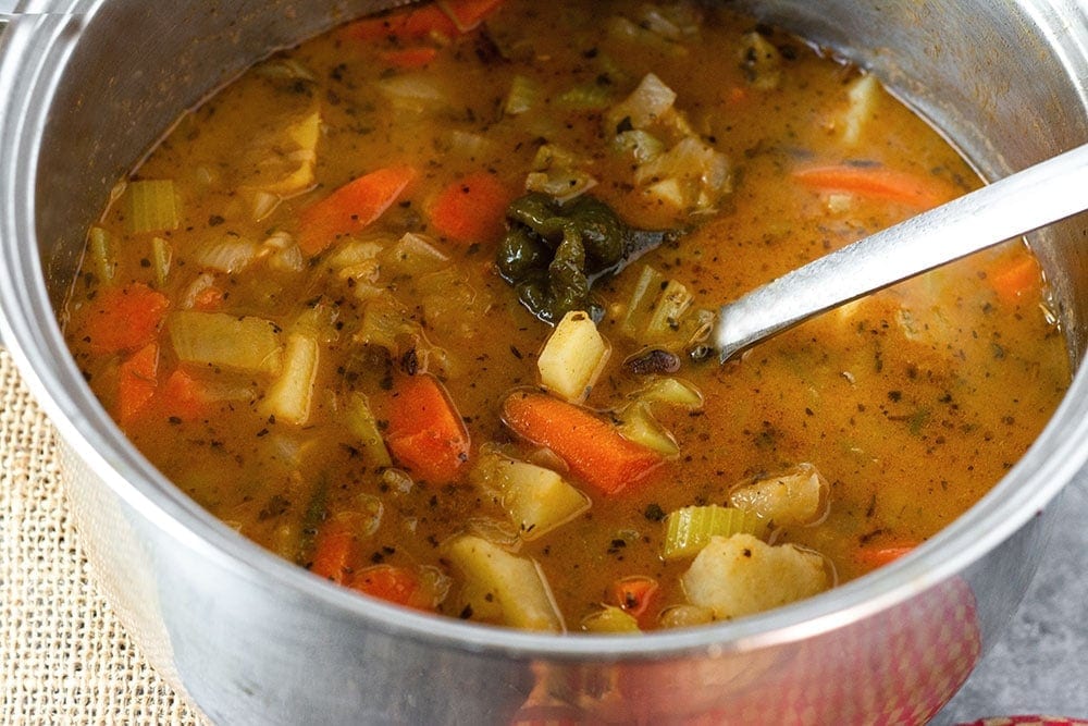 Stainless steel pot of Jamaican pigeon peas stew (gungo peas) a large spoon
