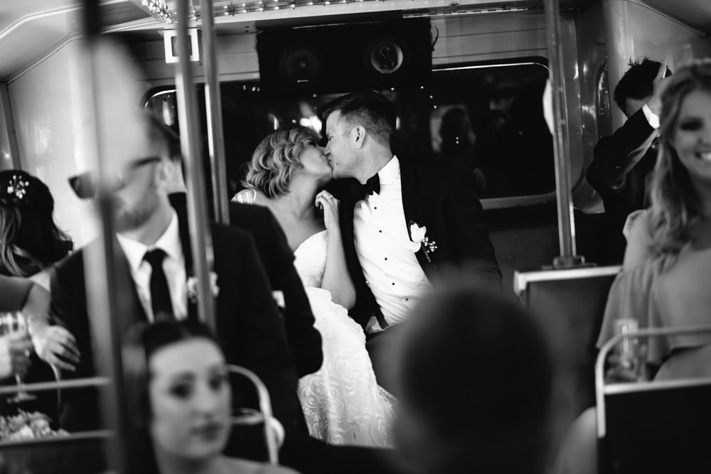 bride and groom kissing on bus